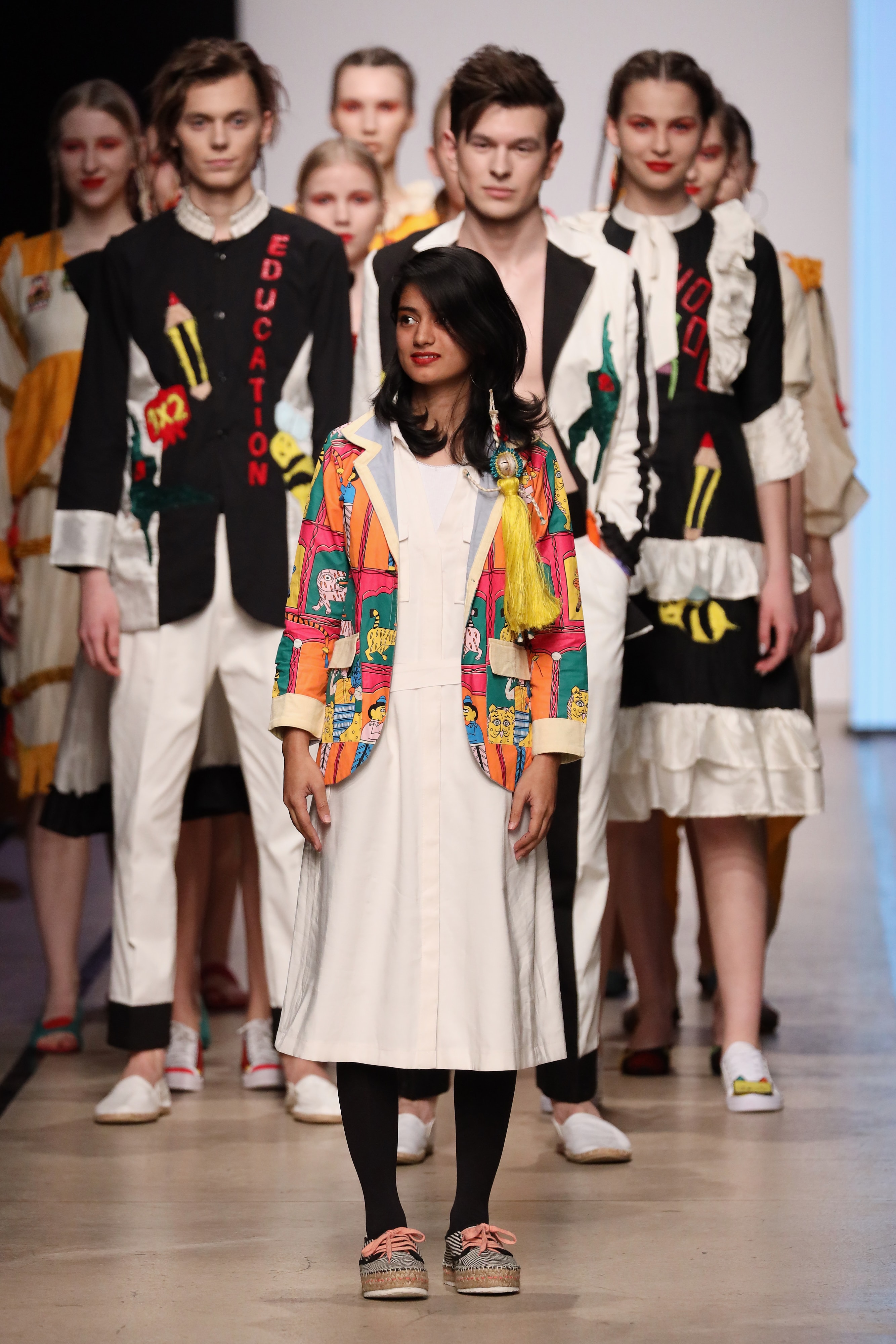 Rokaiya Ahmed Purna standing before models at the MBFW Global Talents runway finale.